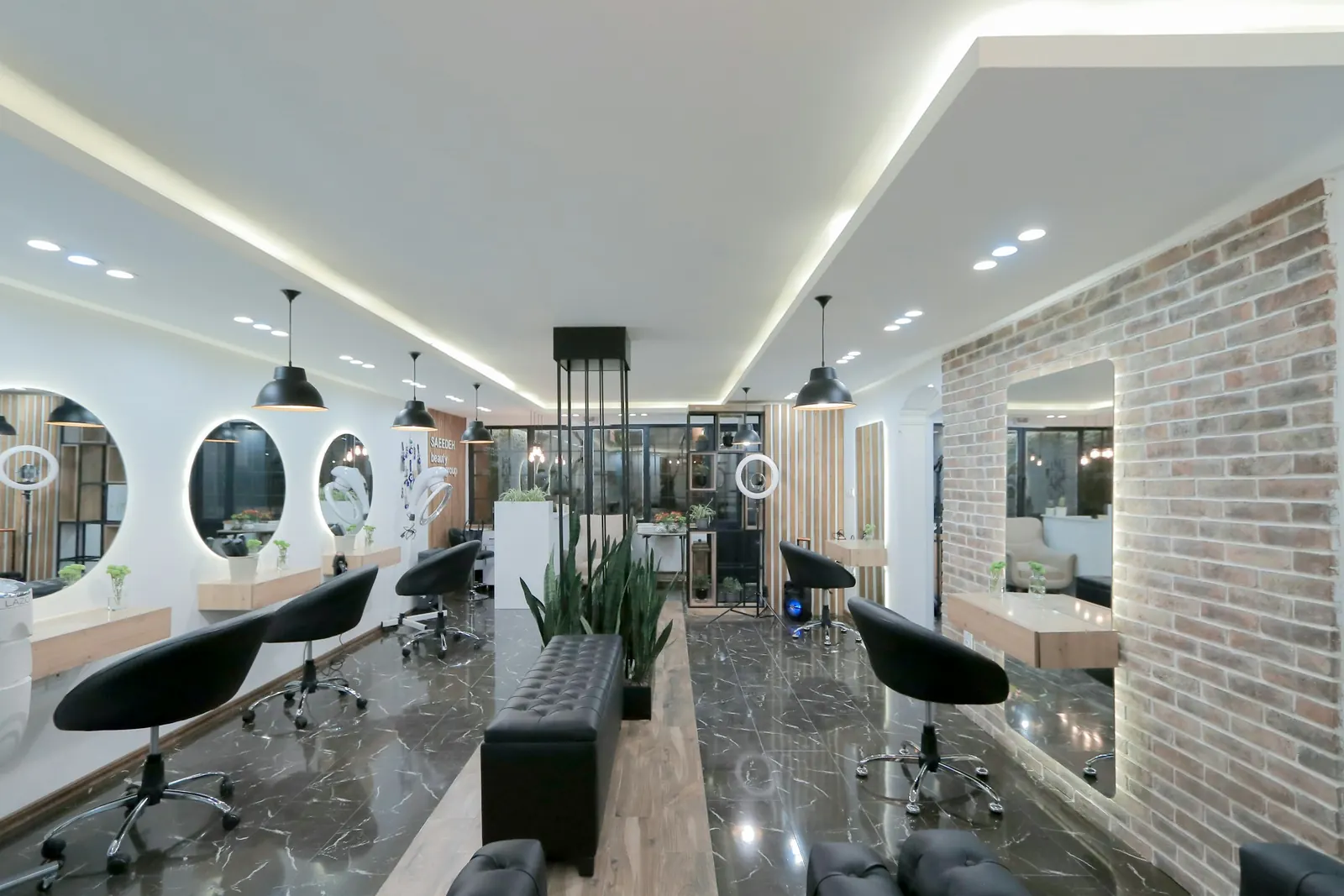 Salão moderno com espelhos redondos iluminados e poltronas pretas