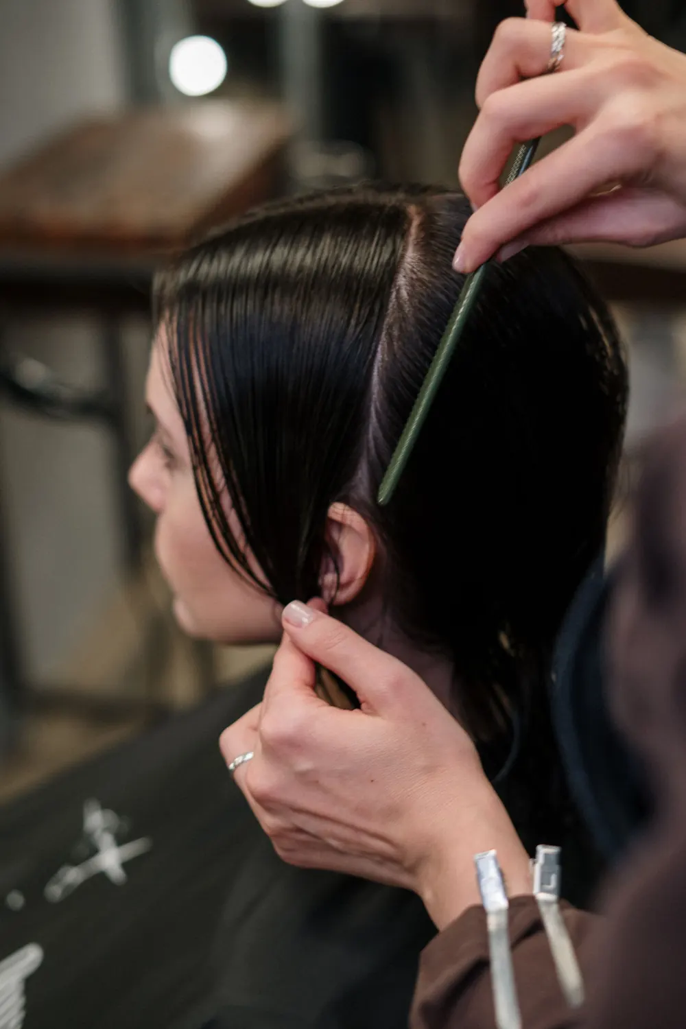 Pente deslizando por cabelo escuro e liso durante o atendimento