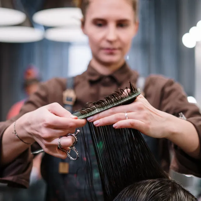 Profissional penteando cabelo longo e escuro
