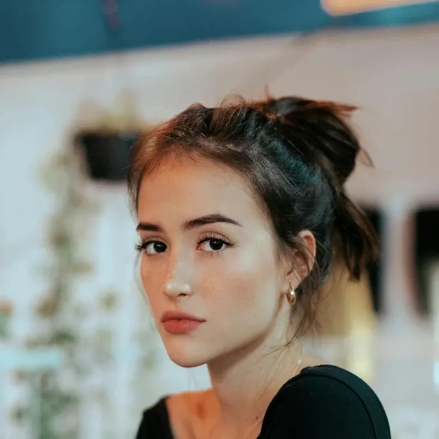 Mulher de cabelo preso sentada no salão