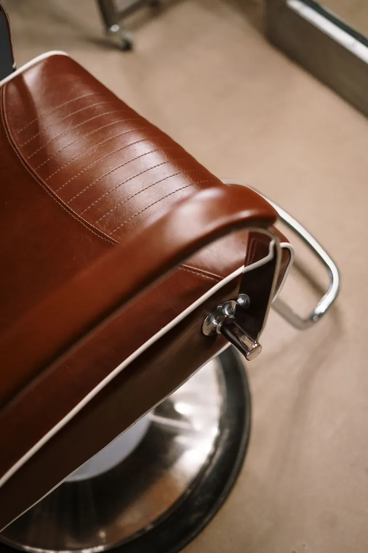 Detalhe de poltrona de couro caramelo no salão